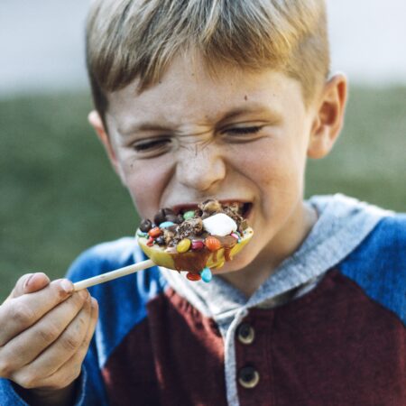 Kid eating apple with toppings